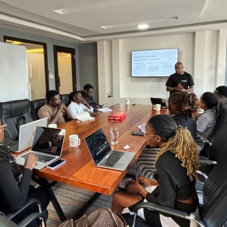 Isaak S. Hayes presenting at Nafasi Design Series in a modern boardroom, engaging a group of startup founders and tech professionals.